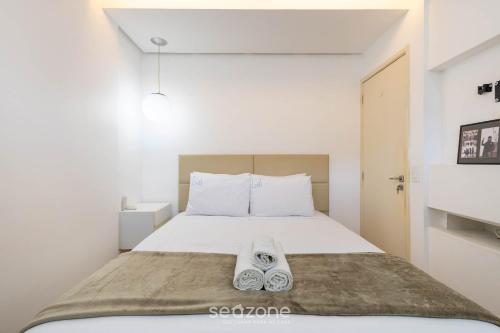 a bedroom with a bed with a pair of shoes on it at Apto c/ Sefl Check-in na Asa Sul SQS0108 in Brasilia