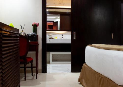 a bedroom with a bed and a desk and a mirror at Hôtel La Villa Racine in Dakar