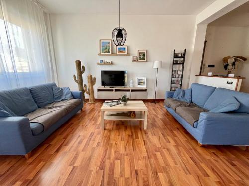 Casa SantaにあるLa Rosa sul Mareの青いソファ2つとテーブルのあるリビングルーム