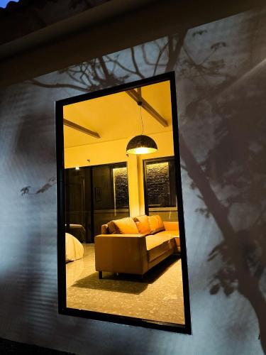 a mirror reflection of a couch in a living room at The Arch Casa - Design Hotel Pai in Pai