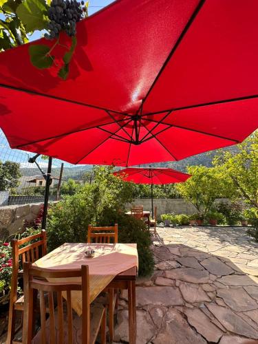 a table with a red umbrella on a patio at Guesthouse SELI in Berat