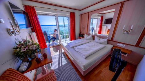 a bedroom with a bed and a view of the ocean at Seehotel ZUR MÜNZ in Meersburg