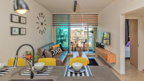 a kitchen and living room with a couch and a clock at Alma in Caesarea