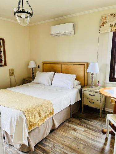 a bedroom with a bed and two tables and two lamps at Hotel El Ciervo in Villarrica