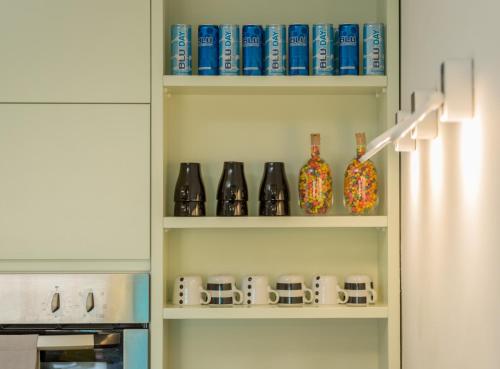a kitchen pantry with bottles and vases on shelves at Alma in Caesarea