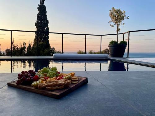 una bandeja de frutas y verduras en una mesa junto a una piscina en CAPE20 Villa Stay, en Ciudad del Cabo