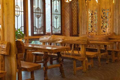 a dining room with wooden benches and stained glass windows at Longsheng Longji Rice Terraces Jingyue Hotel 龙胜龙脊梯田境悦酒店 in Longsheng