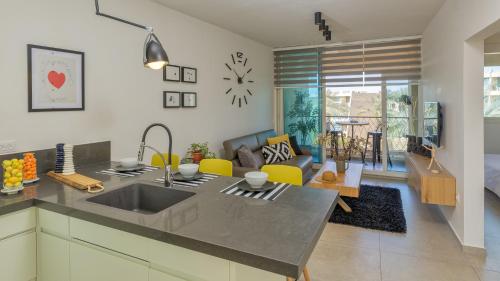 a kitchen with a sink and a living room at Alma in Caesarea