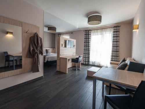 a living room with a bed and a dining room at Ibis Styles Charleroi Airport Aero 44 in Charleroi