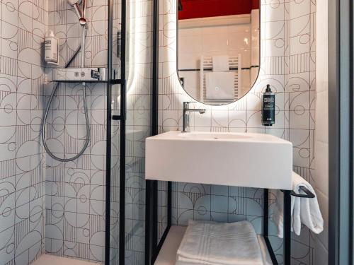 a bathroom with a sink and a mirror at Ibis Styles Charleroi Airport Aero 44 in Charleroi
