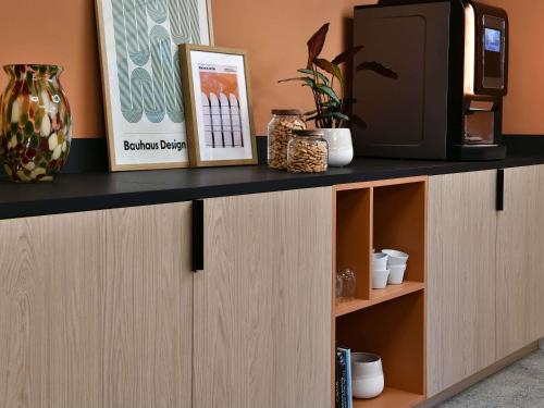 a cabinet with a tv on top of it at Ibis Styles Charleroi Airport Aero 44 in Charleroi