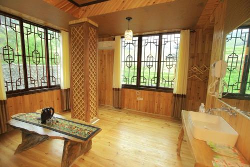 a bathroom with a sink and a table in a room at Longsheng Longji Rice Terraces Jingyue Hotel 龙胜龙脊梯田境悦酒店 in Longsheng