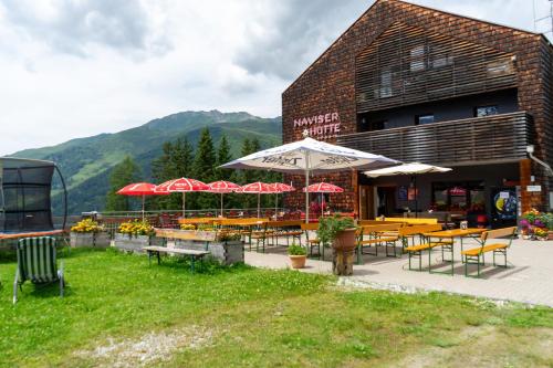 a restaurant with tables and chairs and umbrellas at Wohnung Kreuzjoch 142- Naviser Huette in Navis