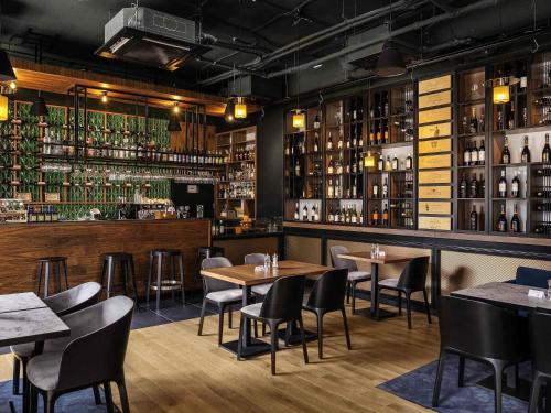 a restaurant with tables and chairs and a bar at ibis Styles Szczecin Stare Miasto in Szczecin