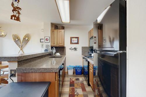 a kitchen with a sink and a black refrigerator at Blue River Escapade in Breckenridge