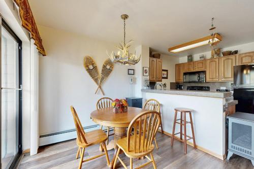 a kitchen and dining room with a wooden table and chairs at Blue River Escapade in Breckenridge