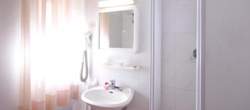a white bathroom with a sink and a mirror at San Gabriele in Loreto