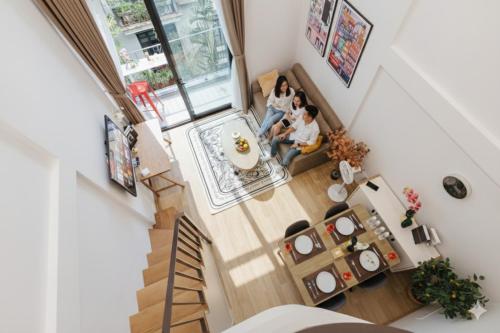 two people sitting in a living room in a house at Margaery Boutique Apartment & Skyon9 Rooftop Bar in Hanoi