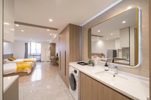 a bathroom with a sink and a bed in a room at Book and Bed - Quyang Apartment in Shanghai