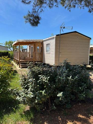 a small house with a porch and a deck at Mobil-home Evasion et confort in Lattes