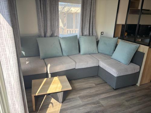 a living room with a couch with blue pillows at Mobil-home Evasion et confort in Lattes