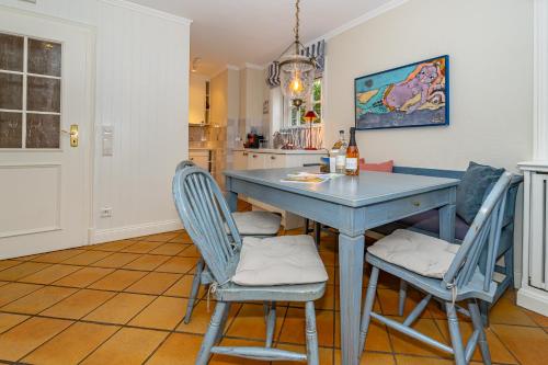 a kitchen with a blue table and chairs at Haus Daanshoog in Keitum