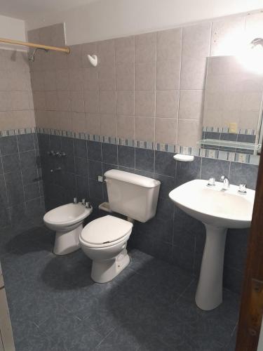 a bathroom with two toilets and a sink at Complejo Vélez Sarsfield 185 in Bell Ville