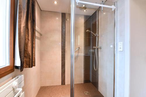 a shower with a glass door in a bathroom at Le BERG'KAY in Kaysersberg