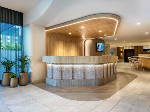 a lobby of a hotel with a reception desk at Novotel Melbourne Preston in Melbourne