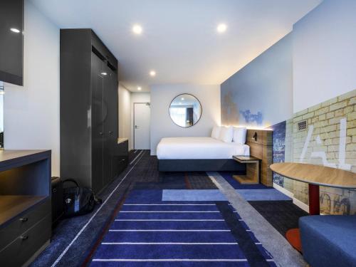 a hotel room with a bed and a bathroom at Novotel Melbourne Preston in Melbourne