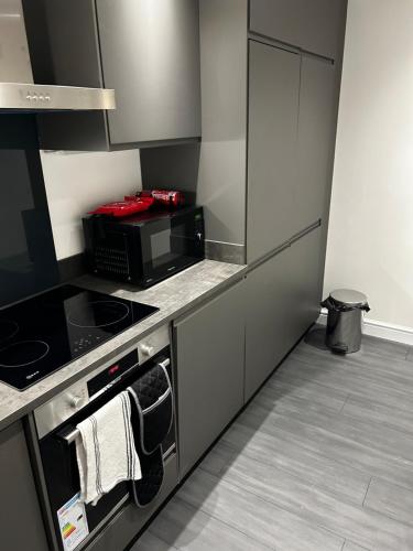 a kitchen with a stove and a microwave at Stunning apartment with parking near Barnsley town centre sleeps 4 in Barnsley