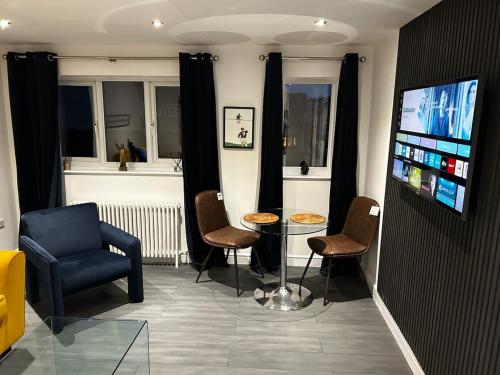 a living room with a table and chairs and a tv at Stunning apartment with parking near Barnsley town centre sleeps 4 in Barnsley