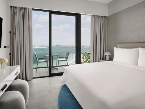 a hotel room with a bed and a view of the ocean at Mövenpick Resort Al Marjan Island in Ras al Khaimah