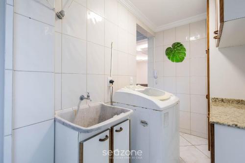 a white bathroom with a sink and a toilet at Apto c/ varanda e churrasq. a 290m do mar CAU0199 in Meia Praia