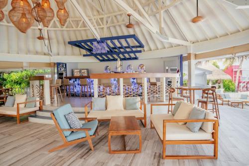 a living room with chairs and a table at Ifuru Island Maldives - FREE Return Domestic Flight for 2 with a minimum 5-night stay until Nov 2025 in Raa Atoll
