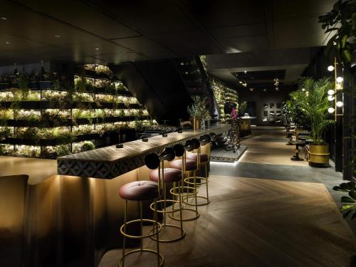 a bar with stools and a counter with wine bottles at Mercure Tokyu Stay Osaka Namba in Osaka