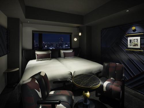 a bedroom with a bed and a table and chairs at Mercure Tokyu Stay Osaka Namba in Osaka