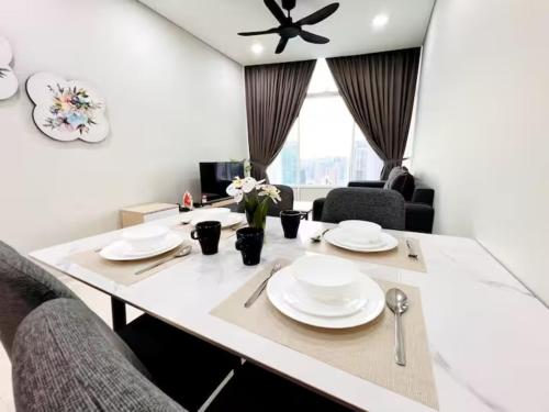 a white dining room table with white plates on it at Luxury Suites Twin Tower in Kuala Lumpur
