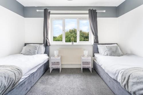 two twin beds in a room with a window at Stylish 2-Bedroom House in Oldbury Sleeps 4 in Oldbury