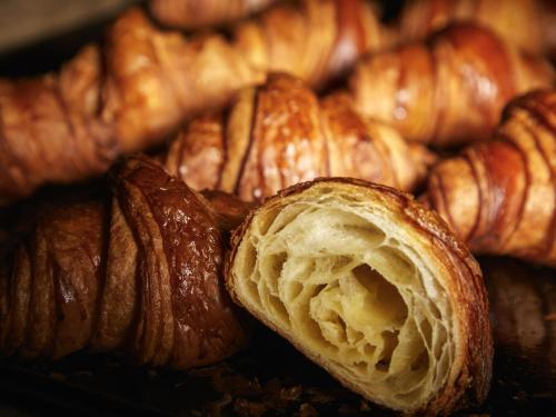 a pile of croissants and other pastries on a table at Mercure Tokyu Stay Osaka Namba in Osaka