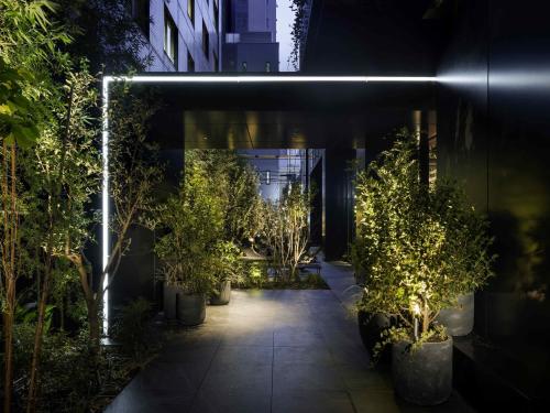 a courtyard with trees and lights in a building at Mercure Tokyu Stay Osaka Namba in Osaka