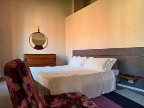 a bedroom with a bed with a mirror on the wall at Ginevra Boutique Rooms - Palazzo Leosini - Residenze D'Epoca in LʼAquila