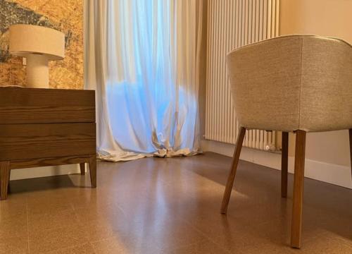 a chair sitting next to a dresser in a room at Ginevra Boutique Rooms - Palazzo Leosini - Residenze D'Epoca in LʼAquila