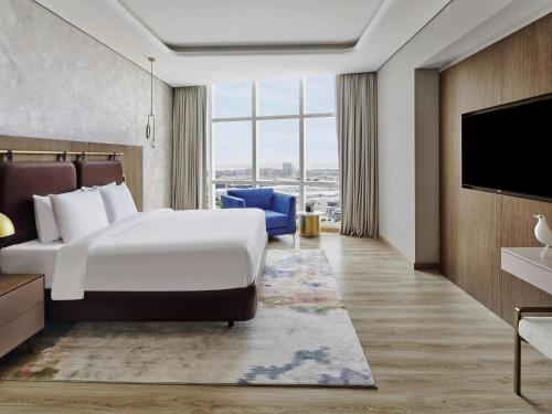 a hotel room with a bed and a flat screen tv at Movenpick Jumeirah Village Triangle in Dubai
