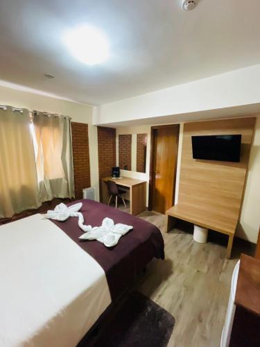 a hotel room with a bed with towels on it at Hotel Garnier in Campos do Jordão