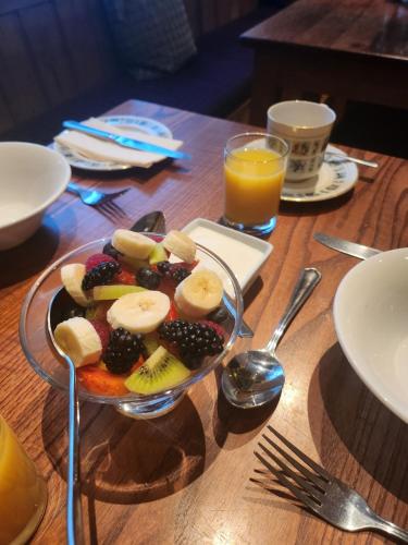a plate of fruit on a wooden table with juice at Anzac Street B+Bistro in Dartmouth