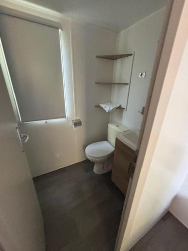 a small bathroom with a toilet and a sink at Mobil-home tout confort in Lattes