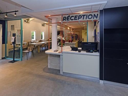 einen Empfangsbereich in einem Zimmer mit Tischen und Stühlen in der Unterkunft ibis Budget La Teste Bassin d'Arcachon in La Teste-de-Buch