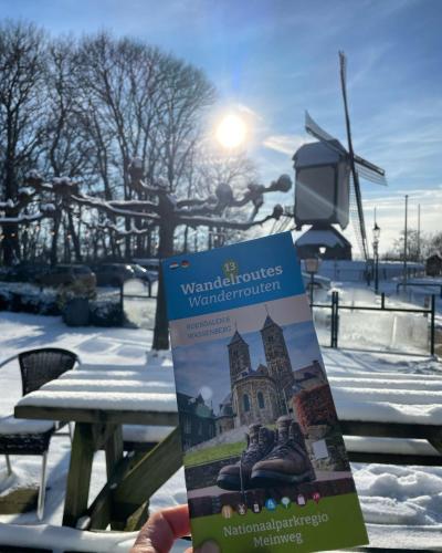 a person holding a sign in front of a park in the snow at De Meuleberg Boutique Suites 