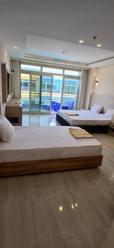 two beds in a large room with a large window at Hurghada Mirage Bay Hotel & Aquapark in Hurghada